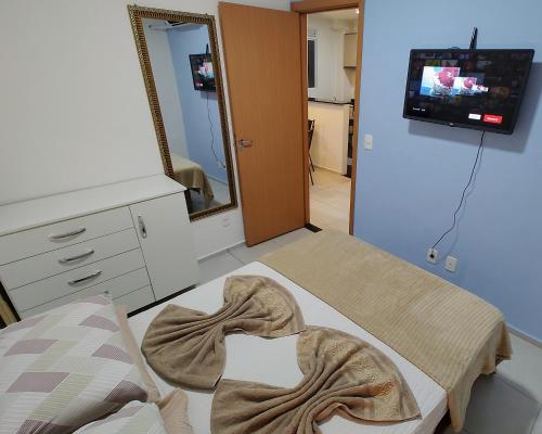 大坎普Apto Executivo Ravena II的客房设有床、镜子和电视