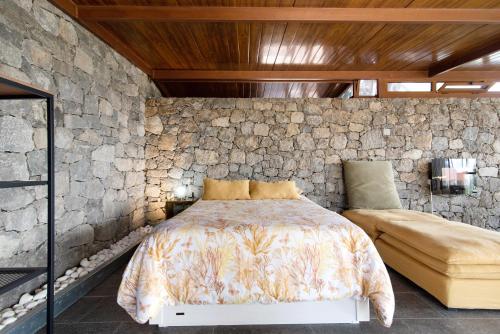 圣布里希达La Casita de la Orilla de Peñate的一间卧室设有一张床和石墙