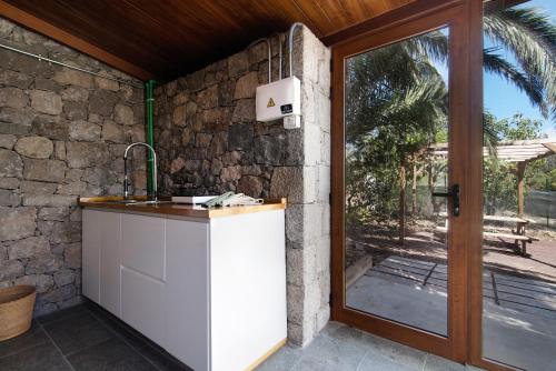 圣布里希达La Casita de la Orilla de Peñate的石墙旁的厨房设有水槽