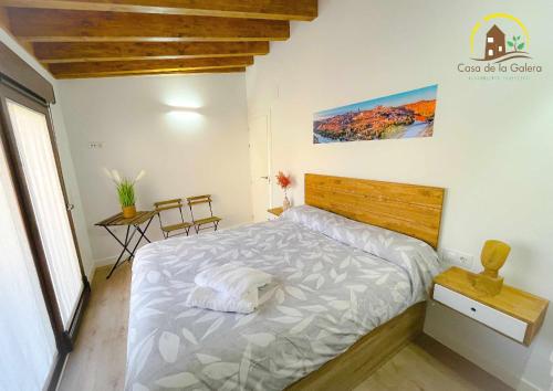 托莱多Casa de la Galera Alojamiento Turístico en Toledo的一间卧室配有一张大床和木制床头板