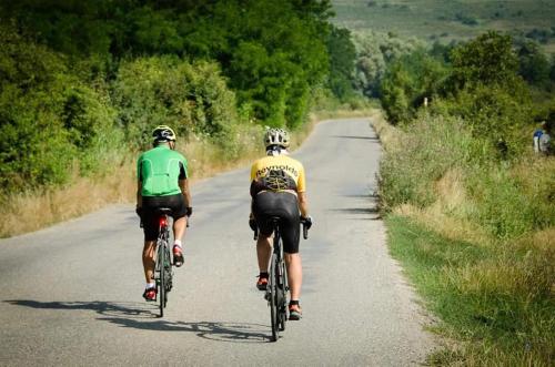 ŞoarşAndrada's House Soars的两个人骑着自行车沿着公路行驶