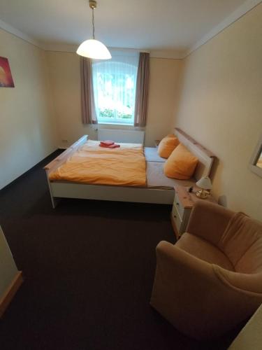 巴特尚道Ferienwohnung 3 Am Zahnsborn的卧室配有床、椅子和窗户。