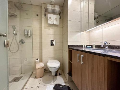 朱尼耶哈亚里套房公寓式酒店的浴室配有卫生间、盥洗盆和淋浴。