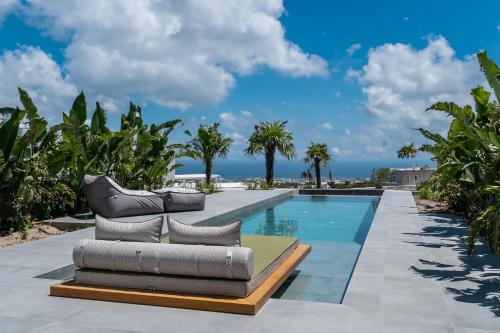费拉Numa Santorini的游泳池旁设有2把躺椅和躺椅