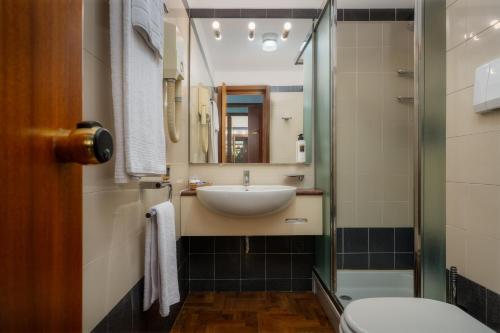 米兰克里维斯酒店的一间带水槽和镜子的浴室