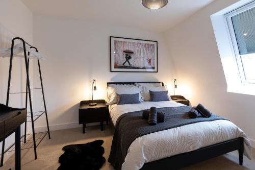 南安普敦Dawson House- gorgeous two bedroom with free parking的卧室配有一张床,地板上放着一条黑色的狗