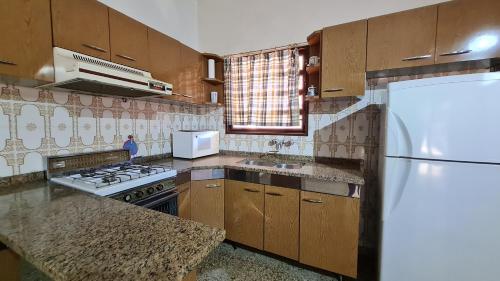 维拉卡洛斯帕兹Casa Rustica的厨房配有木制橱柜和白色冰箱。