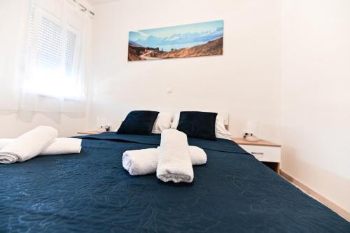 比比涅Apartments MENA的一间卧室配有蓝色的床和毛巾
