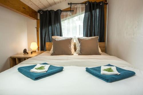 卡布勒通Ocean Garden Surf Lodge的一间卧室配有一张带蓝色毛巾的床