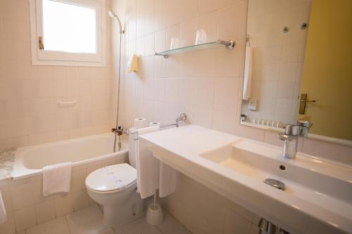 巴加卡阿马伽酒店的浴室配有盥洗盆、卫生间和浴缸。
