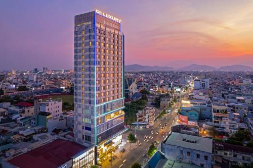 岘港G8 Luxury Hotel and Spa Da Nang的一座高大的建筑,上面有城市的标志