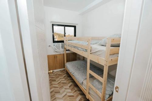 卡尔巴约A’s Penthouse - Calbayog的小型客房设有一张双层床,配有窗户