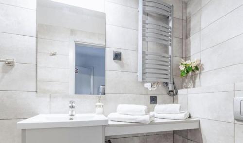 格丁尼亚Guest Apartments Orłowo的白色的浴室设有水槽和镜子
