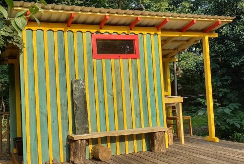 Einfachlosmachen-Zeltpunkt的木制甲板上的黄色和红色的外屋