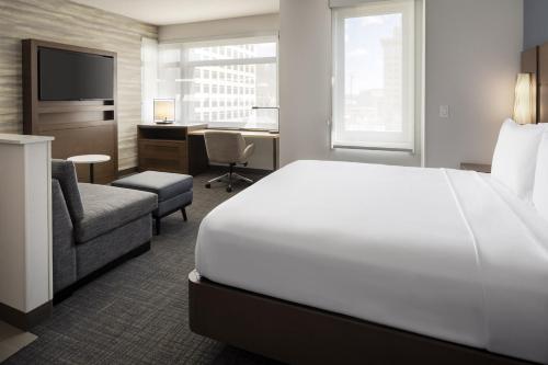 奥克兰Residence Inn by Marriott Oakland Downtown的一间酒店客房,配有一张白色的床和一张书桌