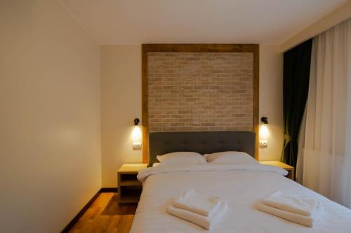 坎普朗莫道尼斯Berghaus Bucovina的卧室配有一张带两个枕头的大白色床