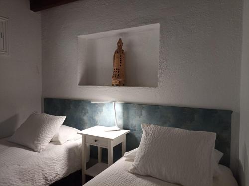 莫卡诺尔Dos Violetas的一间卧室配有两张床和一个带灯的床头柜