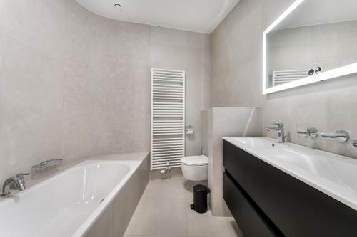 克诺克－海斯特Zonnig Luxueuze Appartementen La Coronne的白色的浴室设有浴缸和卫生间。