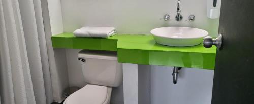 波哥大Hotel Urban Parque 93的一间带绿色水槽和卫生间的浴室