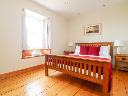 圣贾斯特Boslow的一间卧室配有一张带两个红色枕头的木床