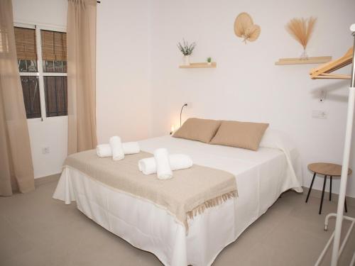 奇克拉纳－德拉弗龙特拉Villa Alegría的白色卧室,配有带毛巾的床