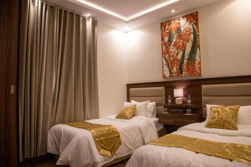 阿尔卡吉صالة وغرفتين نوم دخـول ذاتي的酒店客房设有两张床和窗户。