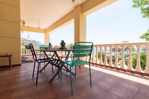 YialósMarika Seaside Villa的阳台的门廊配有桌椅