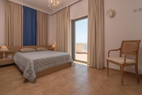 YialósMarika Seaside Villa的卧室配有床、椅子和窗户。