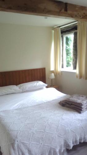 奥尔德姆Millstone cottage的卧室配有一张大白色床和窗户