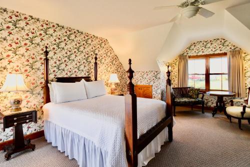 新肖雷汉姆Rose Farm Inn的一间卧室配有一张带花卉壁纸的大床