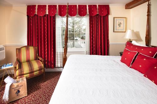 纽波特纽波特美洲帆船旅馆的一间卧室配有床和红色窗帘的窗户