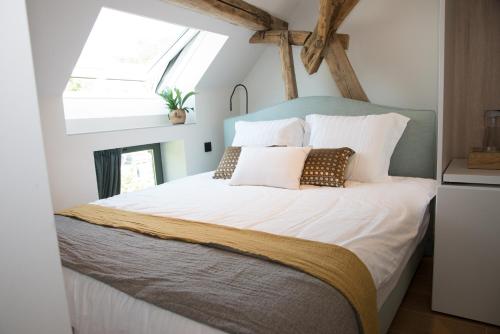 HaachtB&B Kraneveld的卧室配有一张带白色床单和枕头的大床。
