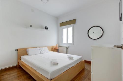 圣阿德里安-德贝索斯Barcelona Beach Vibes的卧室配有一张床,墙上挂着一个钟