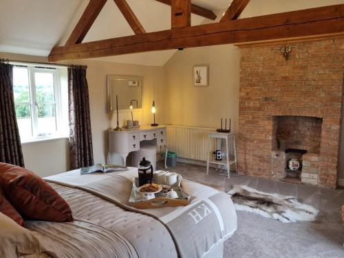 梅尔顿莫布雷Paddock Cottage - Thorpe Arnold Melton Mowbray的客厅设有一张床和一个壁炉