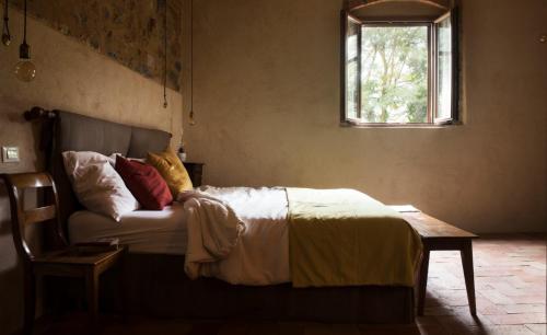 圣吉米纳诺Agriturismo I Pini的一间卧室配有一张床、一张桌子和一个窗户。