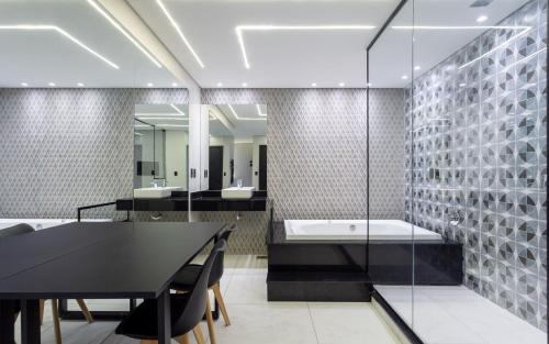 阿雷格里港Drops Motel POA Zona Sul的浴室配有黑色桌子和浴缸。