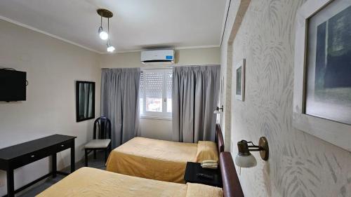 圣罗莎Calfucura Apart Hotel的酒店客房配有两张床和一张书桌