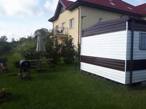 梅尔诺Domek Holenderski的院子旁的一座房子,设有白色和黑色的车库