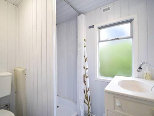 梅尔诺Domek Holenderski的白色的浴室设有水槽和窗户。