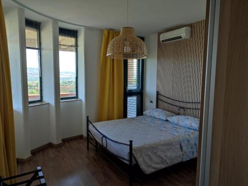 阿布鲁齐的罗塞托Villa Giuseppe的一间卧室配有一张床、一个吊灯和两个窗户。
