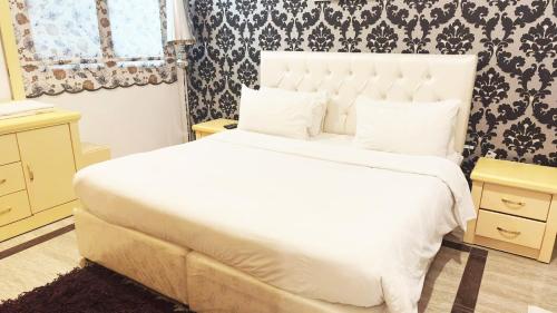 科威特Hotel Leaders Plaza Salmiya的卧室设有一张白色大床和一扇窗户。