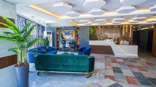 ArnavutköyLuxury Airport Hotel的客厅设有绿色沙发和楼梯。