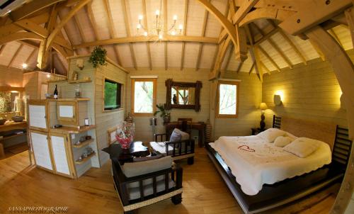 贝济耶爱的小屋酒店的一间带一张大床的卧室,位于一个拥有木制天花板的房间