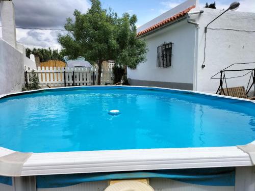 贝纳卢普-卡萨斯维耶哈斯El Capricho的一座大蓝色游泳池,位于房子前