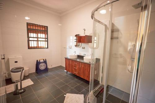 坎帕拉The Forest House - Kawuku-Bunga的带淋浴、盥洗盆和卫生间的浴室