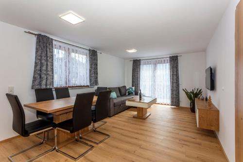 皮森多夫Villa Oberbichl的客厅配有桌子和沙发