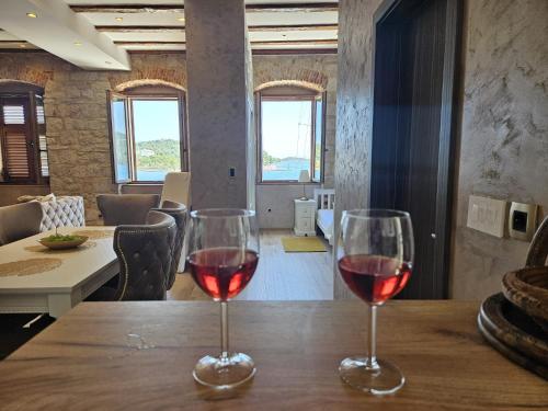 维斯Luxury Seafront Suite Fabri的木桌旁放着两杯红葡萄酒