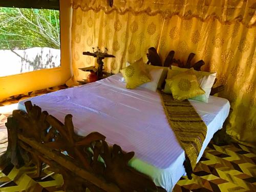 雅拉Podi Hoona Luxury Bush Camp的一间卧室配有一张带木制床头板的床