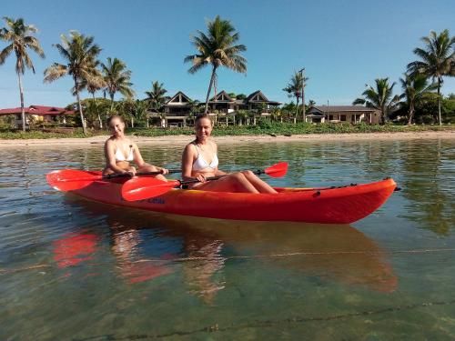 辛加东卡Seaside Villa的两个女人坐在水里红皮艇里