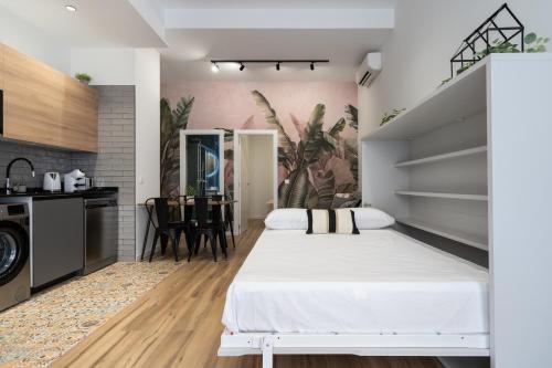 瓦伦西亚Beach Apartments Valencia的一间带白色床的卧室和一间厨房
